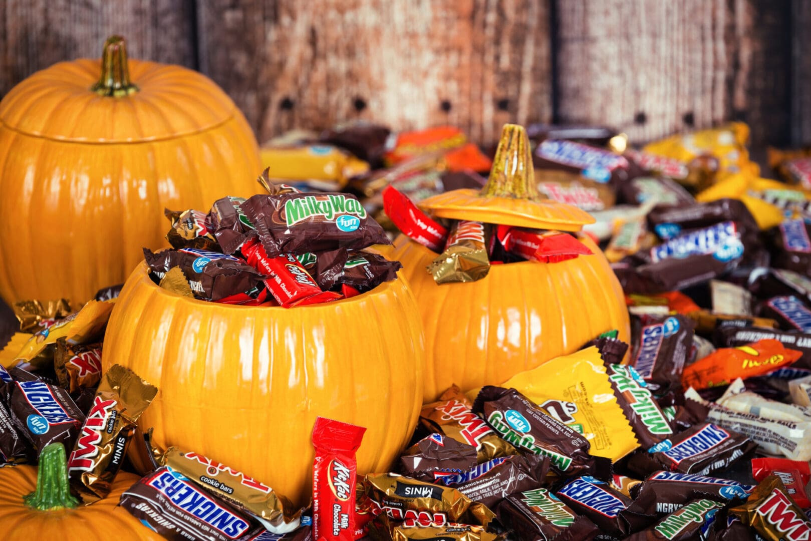 Dallas, United States - October 31, 2015: Decorative pumpkins filled with assorted Halloween chocolate candy made by Mars, Incorporated and the Hershey Company.