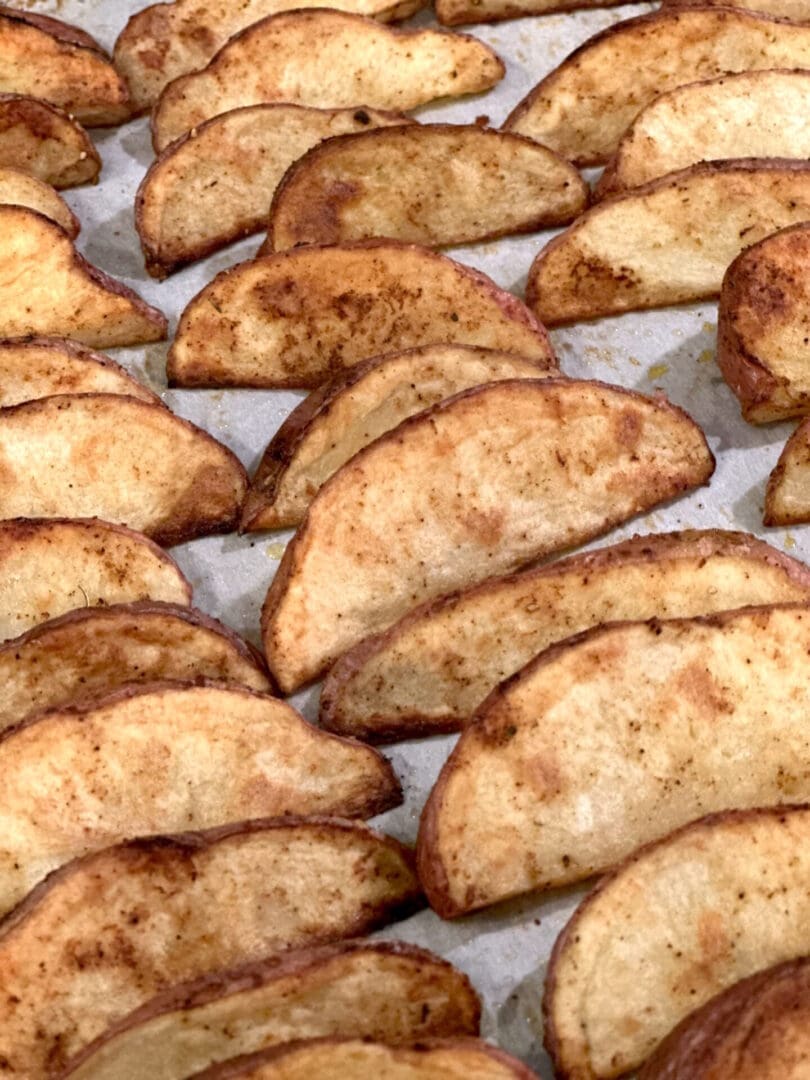 Baked potato wedges on a baking sheet.