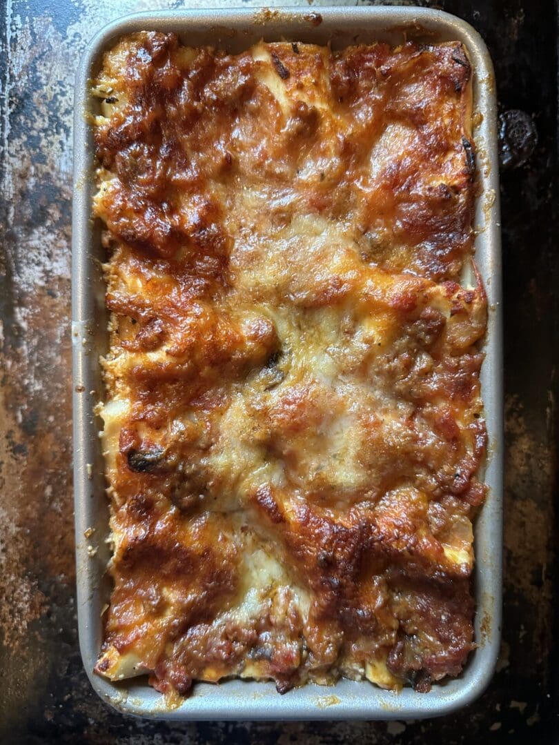 Lasagna in a baking dish on top of a stove.