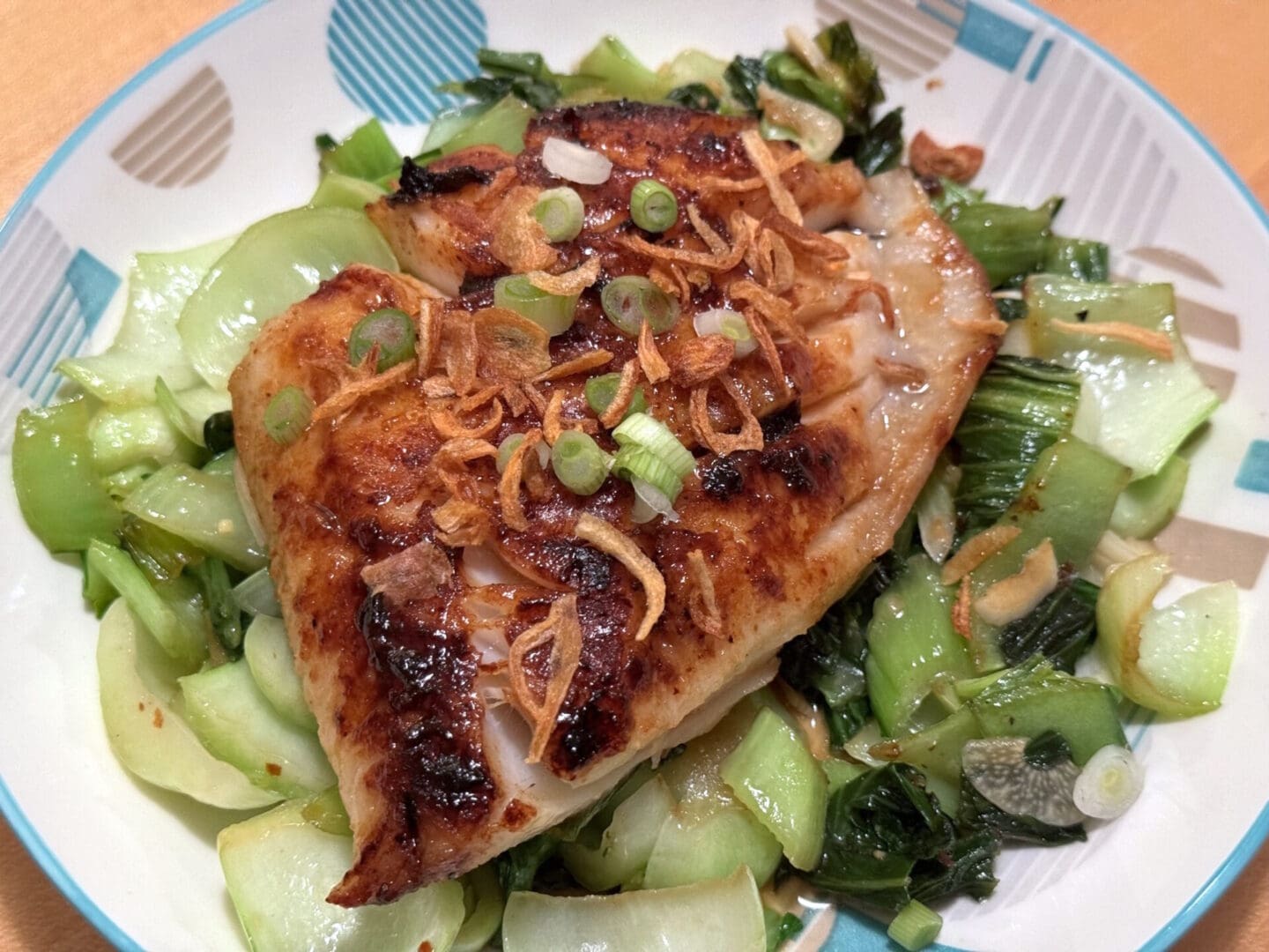 Grilled fish with bok choy and crispy onions.