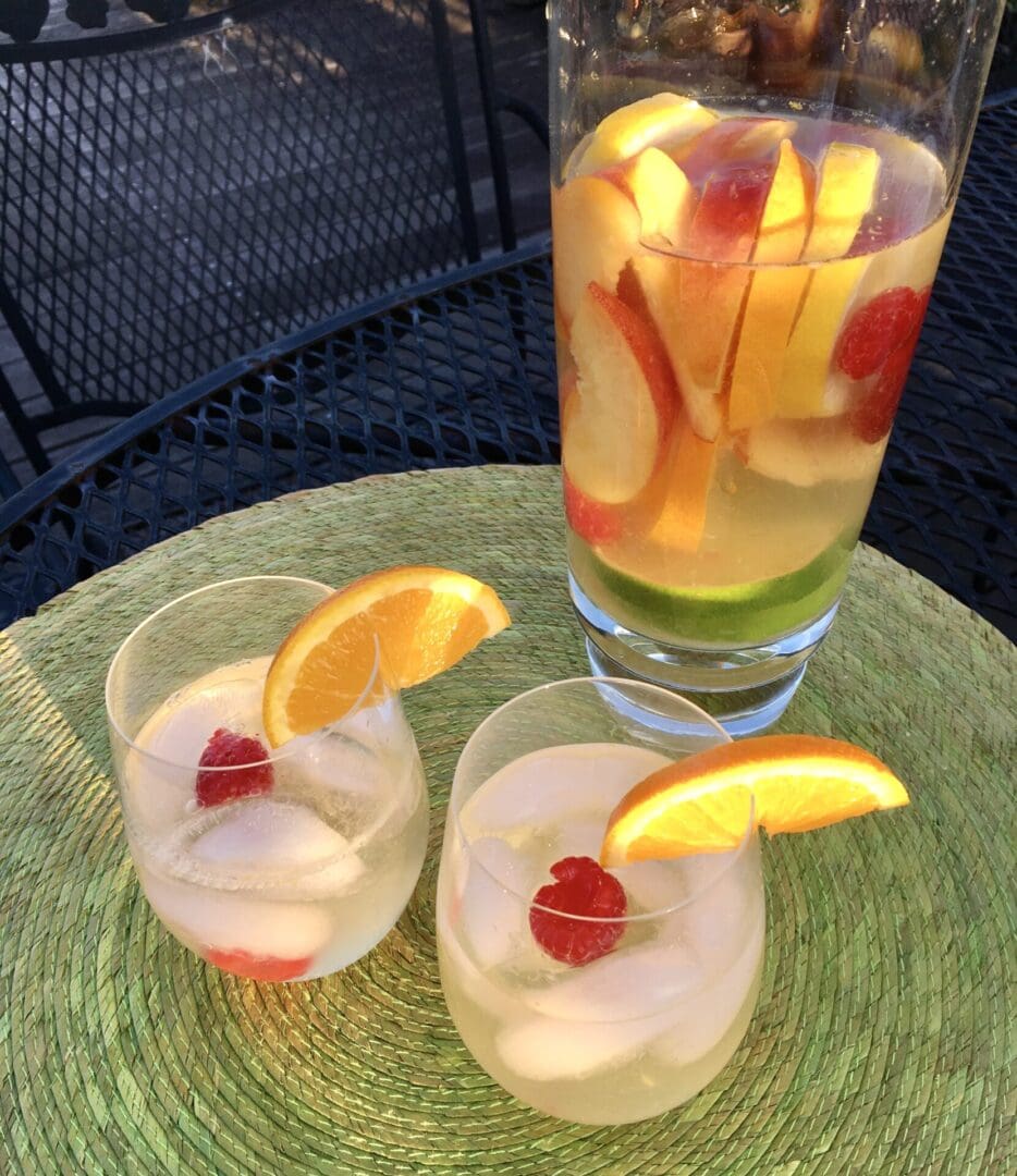 Two glasses of white wine sangria with fruit.