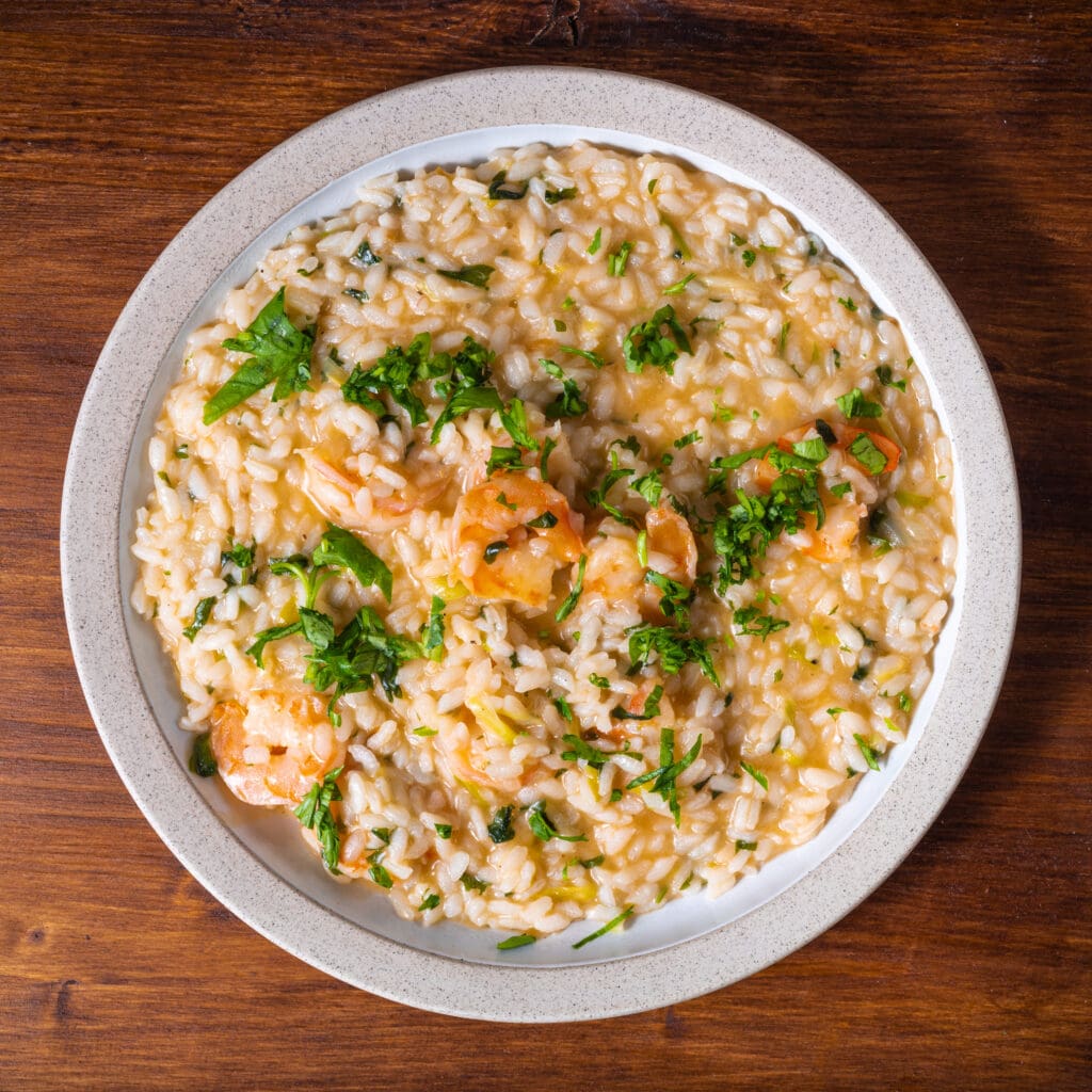 Shrimp risotto with parsley in a bowl.