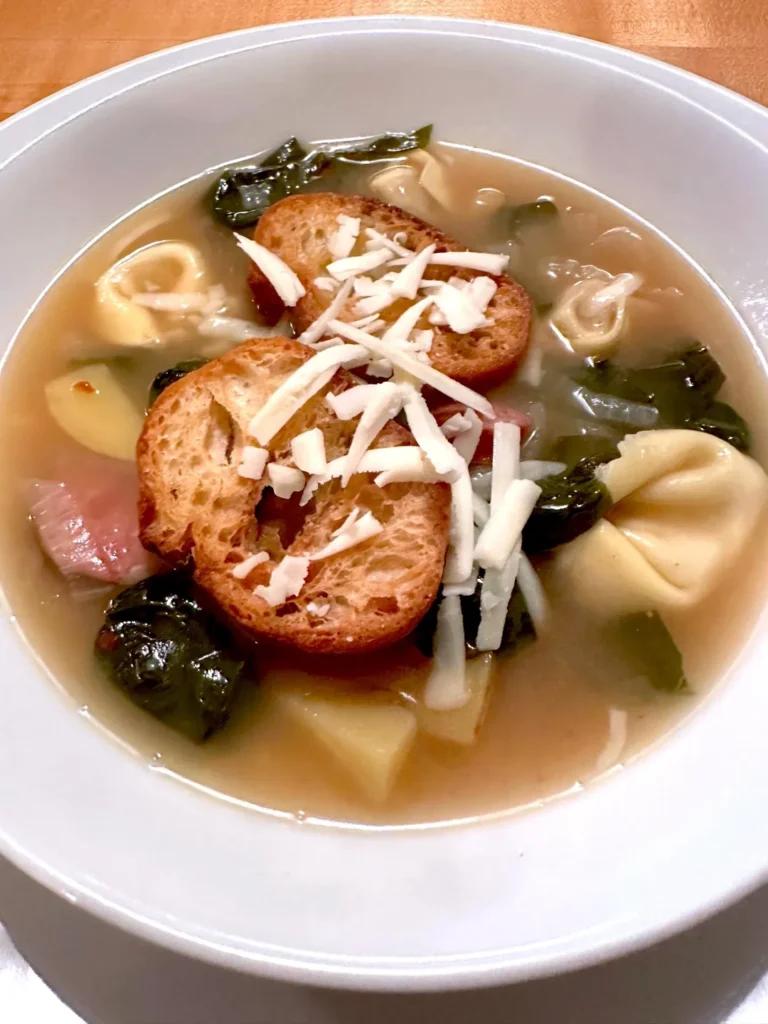 Tortellini soup with croutons and cheese.