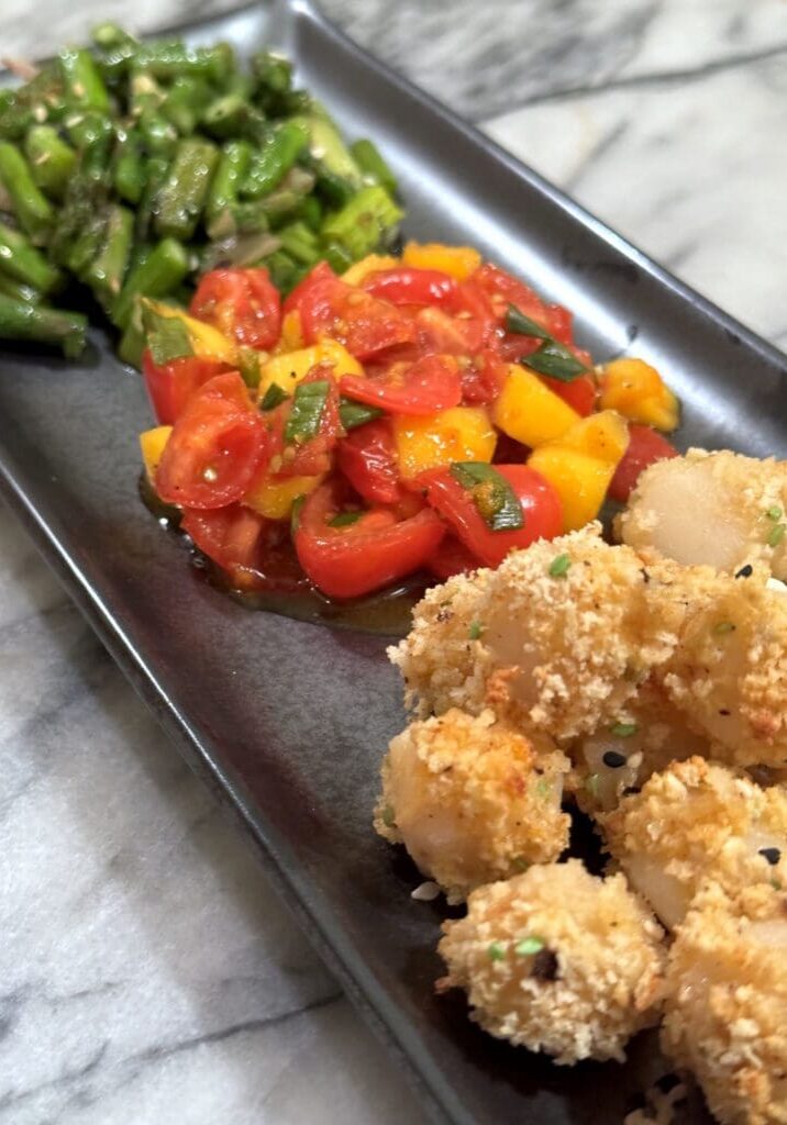 Fried seafood, tomato salad, and asparagus.