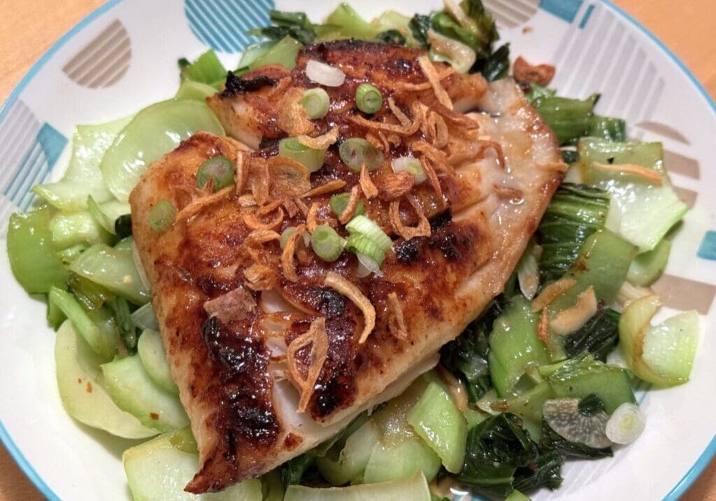 Grilled fish with bok choy and crispy onions.