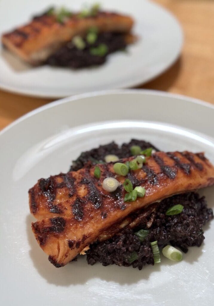 Grilled salmon on black rice with scallions.