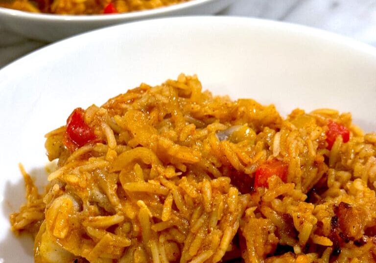 A plate of chicken and rice with peppers.