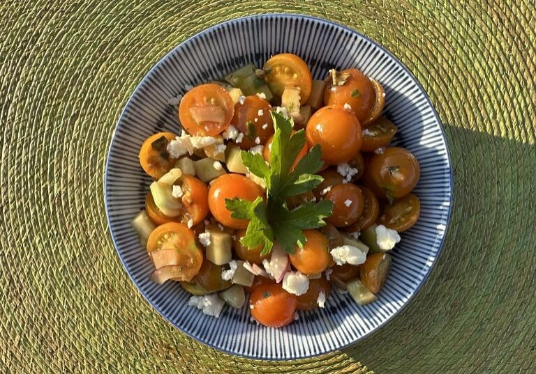 Tomato salad with feta and parsley in a bowl.