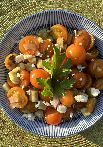 Tomato salad with feta and parsley in a bowl.