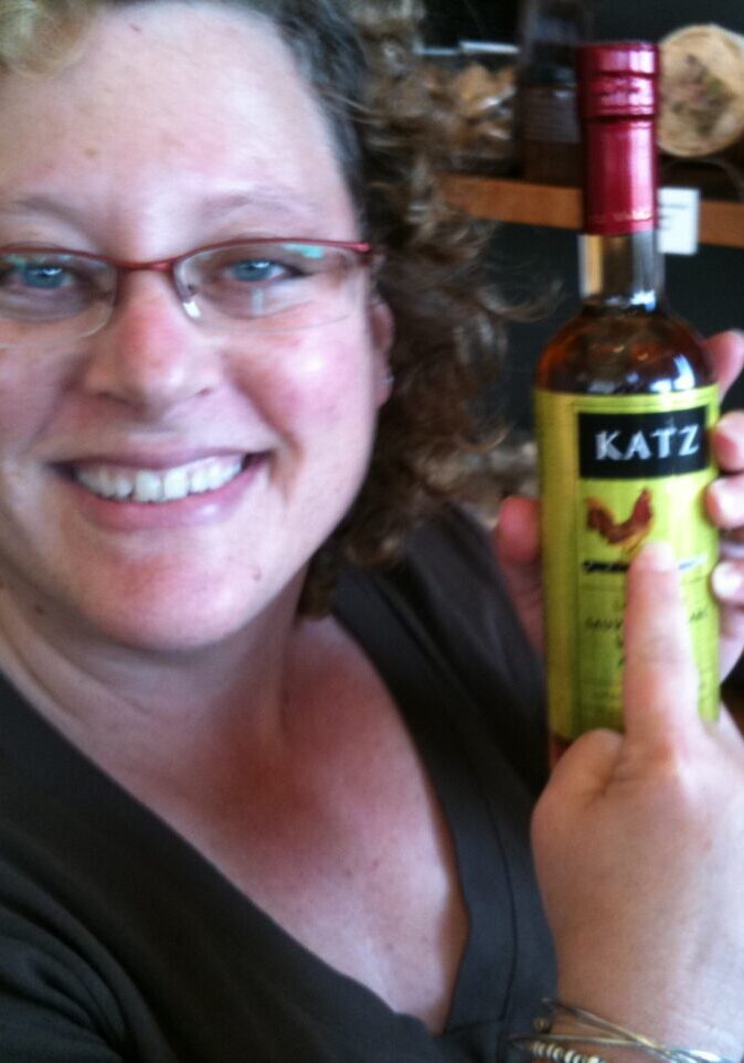 A Woman in Glasses Holding Out a Katz Bottle