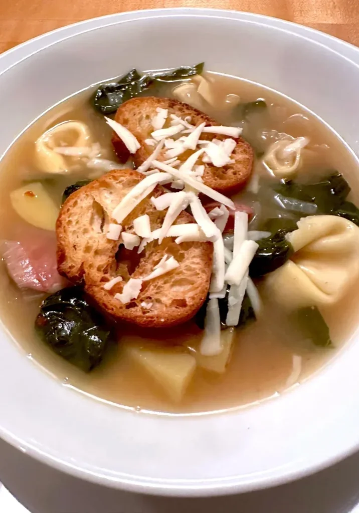 Tortellini soup with croutons and cheese.