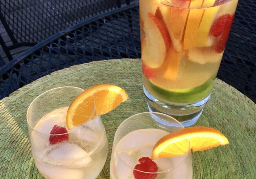 Two glasses of white wine sangria with fruit.