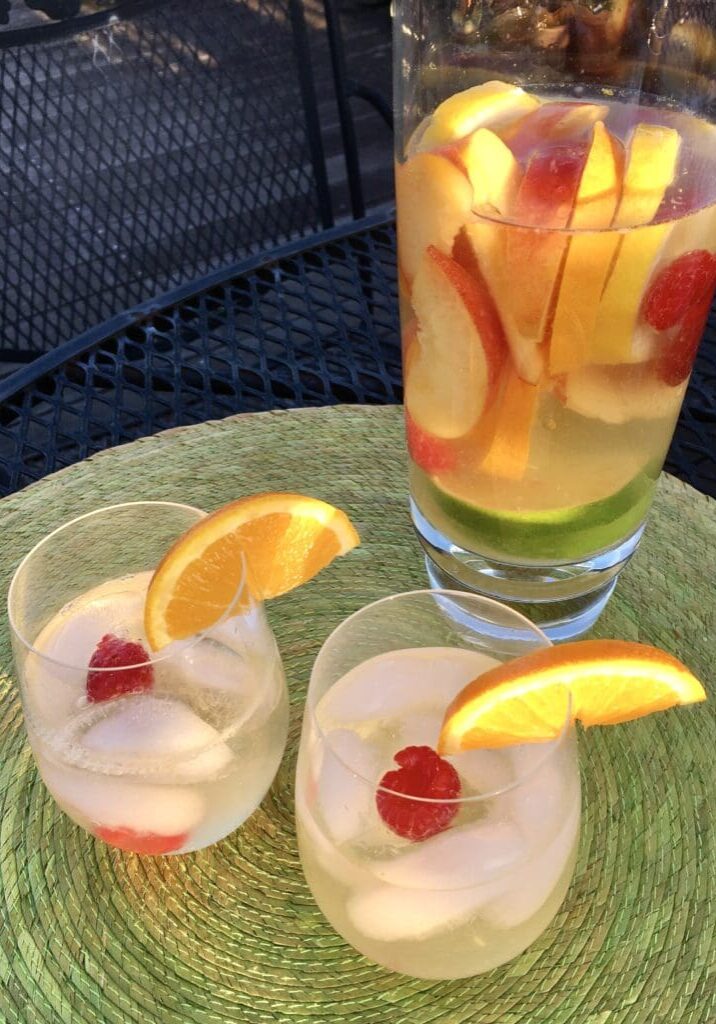 Two glasses of white wine sangria with fruit.